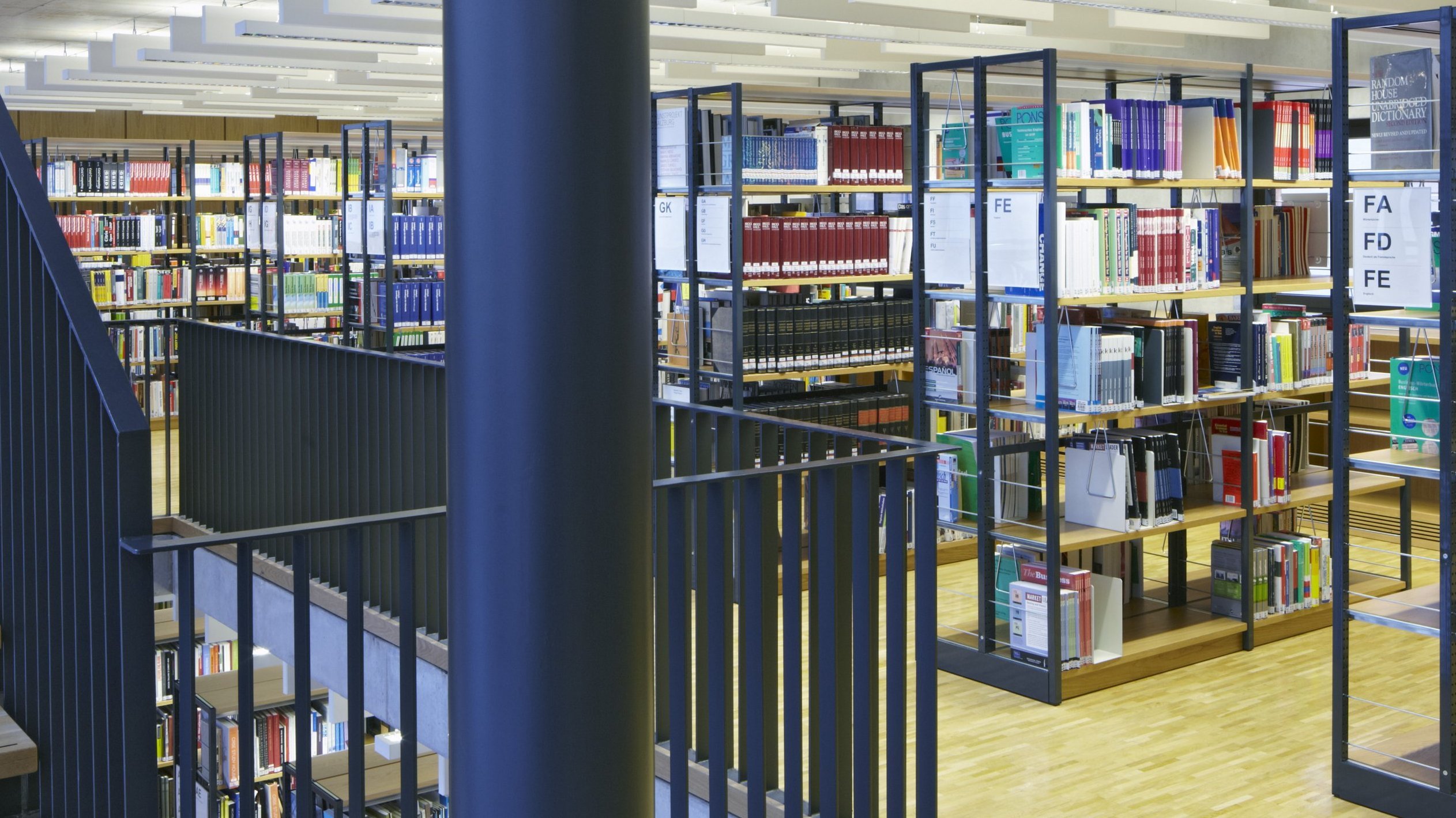 Bild des Eingangs der Bibliothek mit einer Treppe und Bücherregalen 
