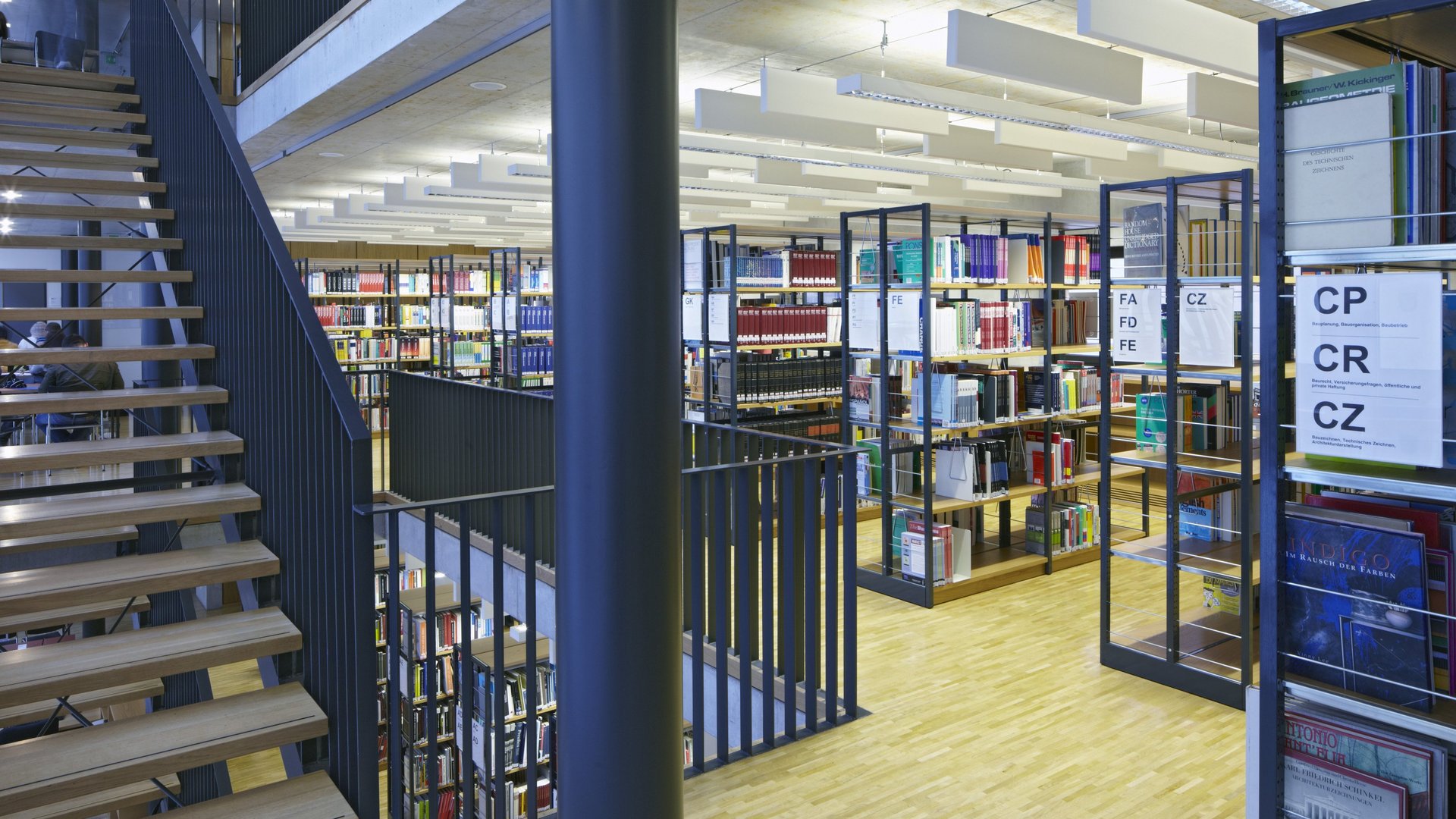 Bild des Eingangs der Bibliothek mit einer Treppe und Bücherregalen 