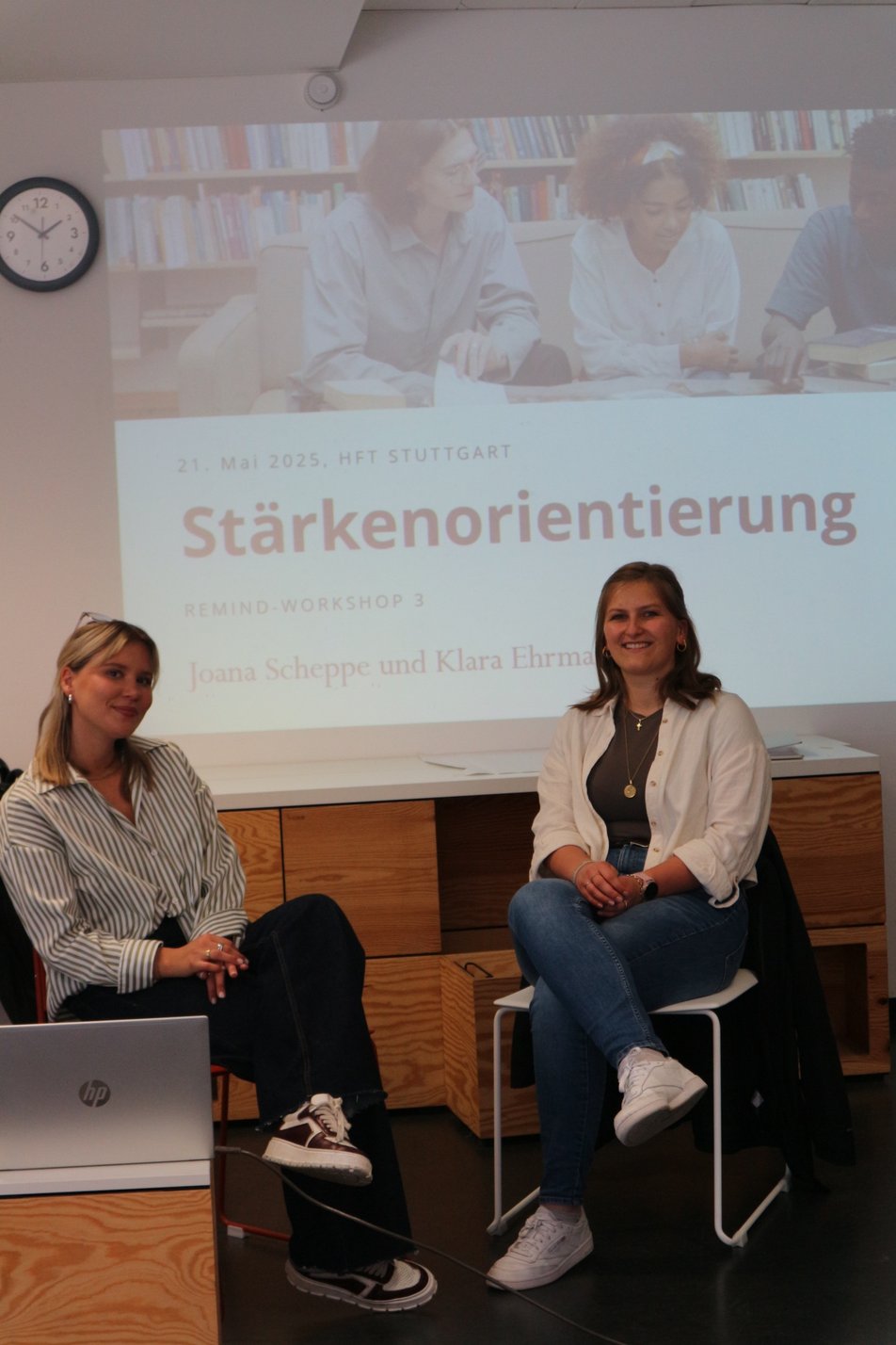 Zwei Kursleiterinnen sitzen vor einer Präsentation mit dem Titlel Stärkenorientierung