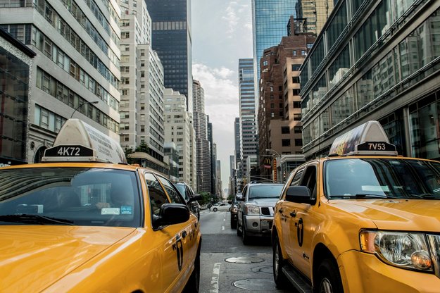 Frontansicht von Taxis in einer Straße mit Hochhäusern im Hintergrund