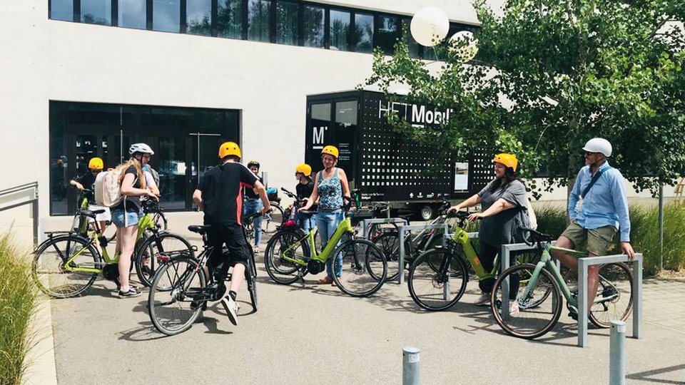 Studierende, die sich während der Summer School vor dem Gebäude der Fakultät Architektur und Gestaltung mit E-bikes versammelt haben