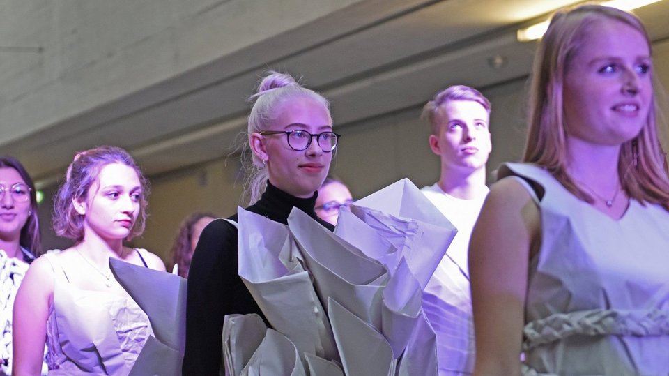 Studierende präsentieren Kleider aus Papier bei Modenschau