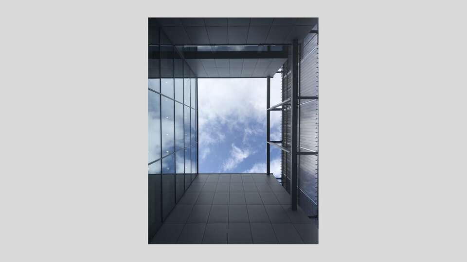 Architekturfotografie einer Gebäudefassade mit Himmel im Hintergrund