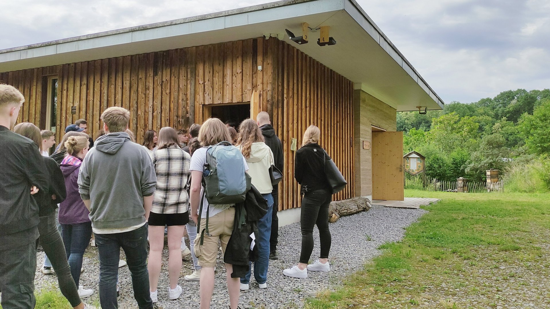 Studierende stehen vor einem Lehmgebäude