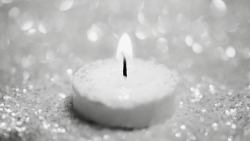 Kerze mit hellem Hintergrund in schwarz-weiß
