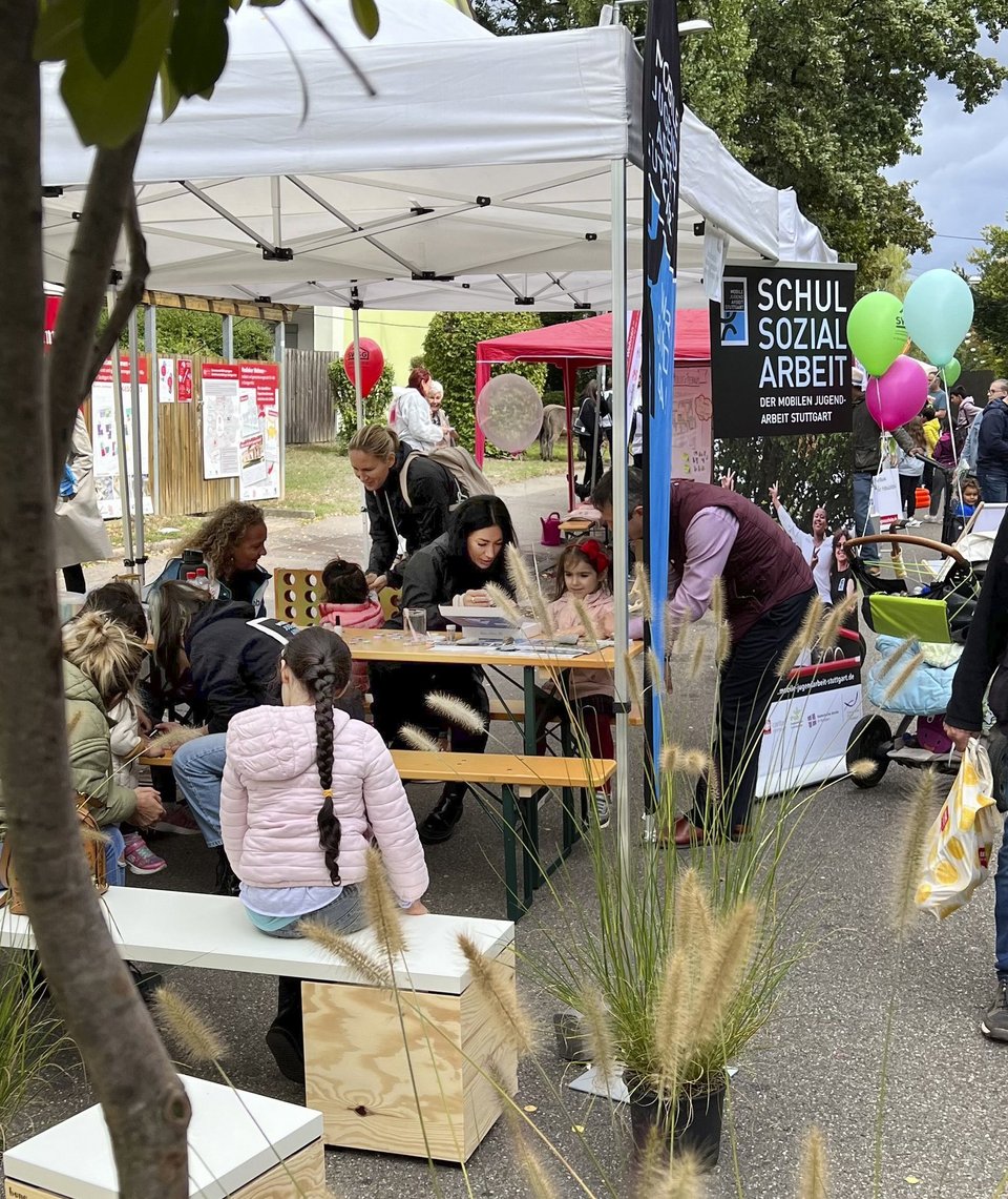  Menschen sitzen am Stand auf Bänken