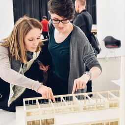 Zwei Studierende betrachten ein Modell bei der Ausstellung 