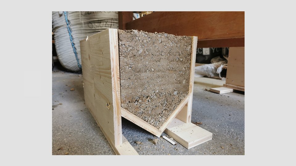 Bauen mit Naturmaterialien – Abbildung einer Architektur aus Stampflehm in Holzverschalung