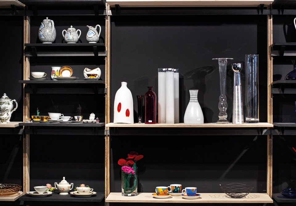 Tonis Ladencafé – Foto mit Vasen und Objekten in Regalfächern