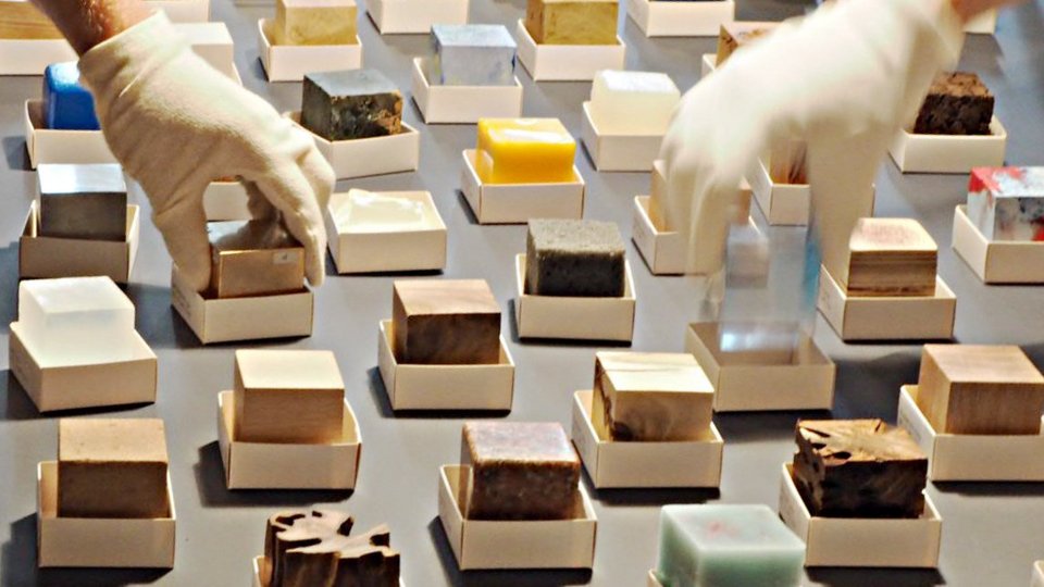 Hände greifen verschiedene Materialien in Würfelform