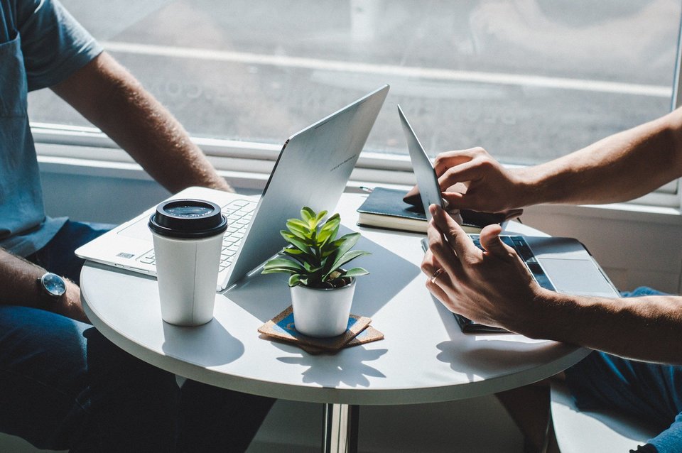 Zwei Personen arbeiten an Laptops