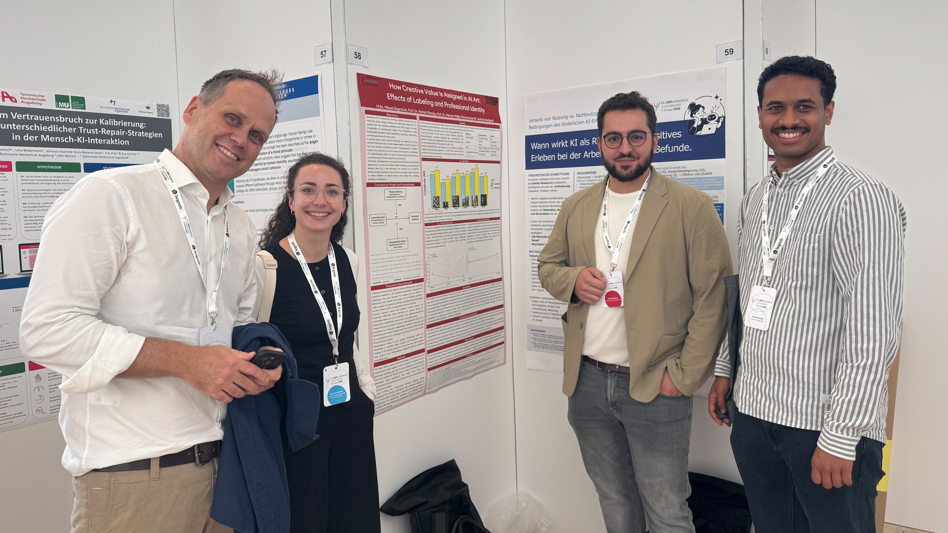 Gruppenbild: Vier Forschende der HFT Stuttgart und Hochschule Luzern vor Poster-Session auf dem DGPs-Kongress. Im Hintergund sind vier Poster zu sehen.