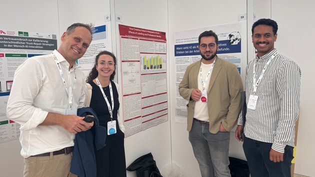 Gruppenbild: Vier Forschende der HFT Stuttgart und Hochschule Luzern vor Poster-Session auf dem DGPs-Kongress. Im Hintergund sind vier Poster zu sehen.