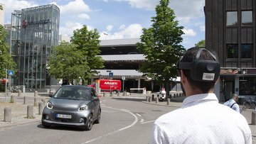 Ein Mann schaut mit VR-Brille in eine gewundene Straße 