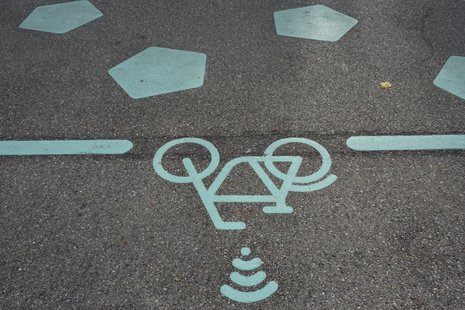 Fahrradsymbol auf Straße mit wifi Zeichen