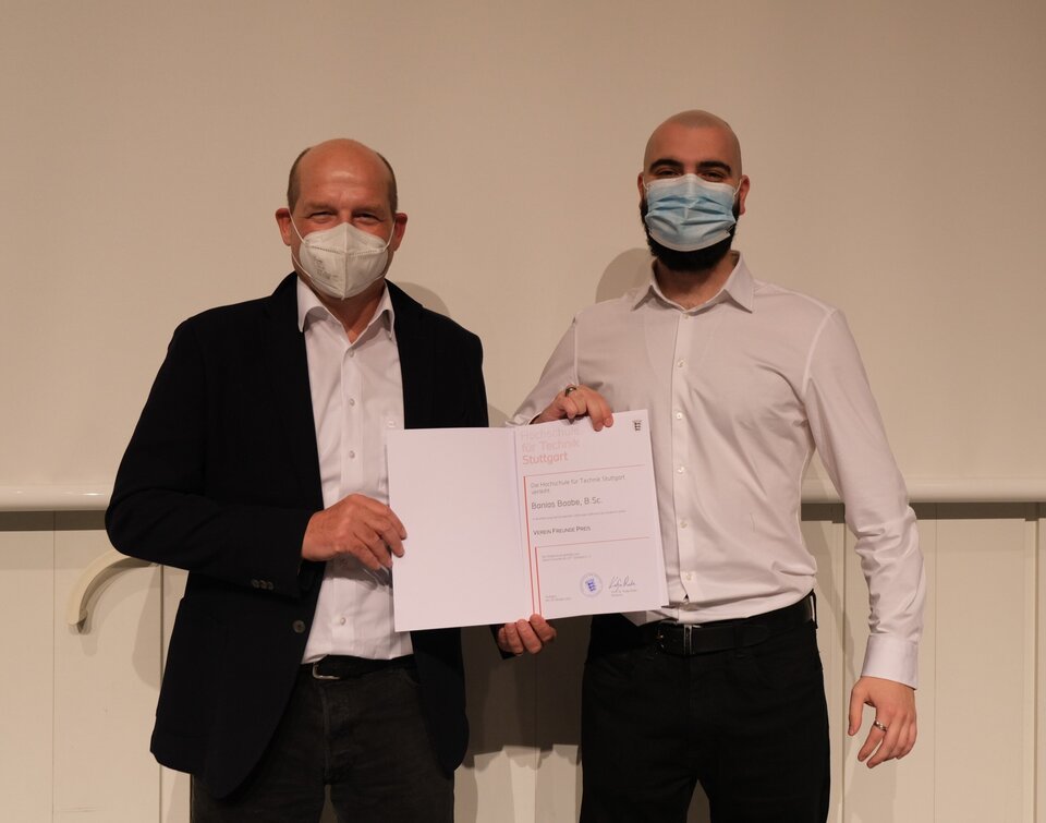 Zwei Personen auf einer Bühne mit Urkunde