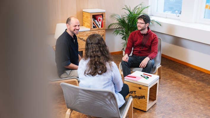 Drei Mitarbeitende unterhalten sich