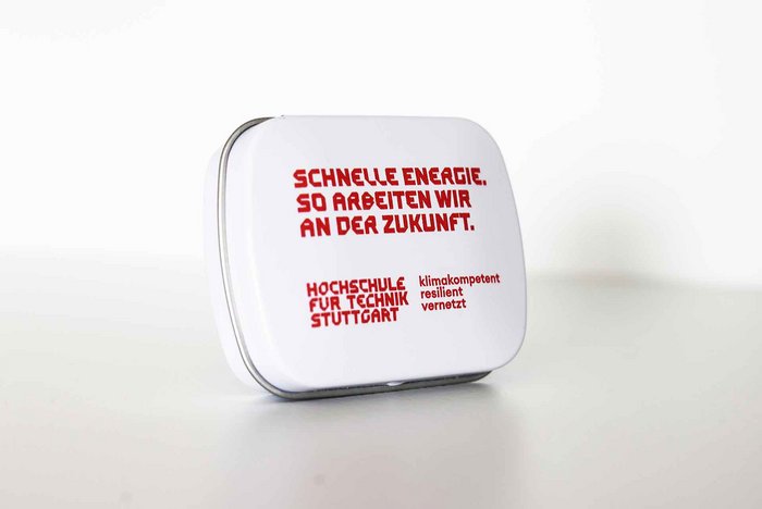 Weiße Traubenzuckerdose mit roter Aufschrift "Schnelle Energie. So arbeiten wir an der Zukunft." und rotem Logo der HFT Stuttgart