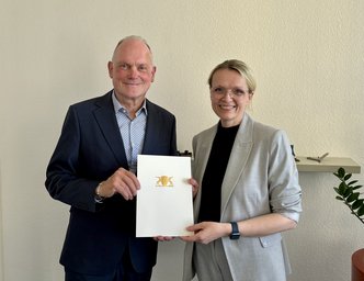 Brigitte Heintz-Cuscianne erhält die Urkunde von Ministerialdirektor Dr. Hans J. Reiter.