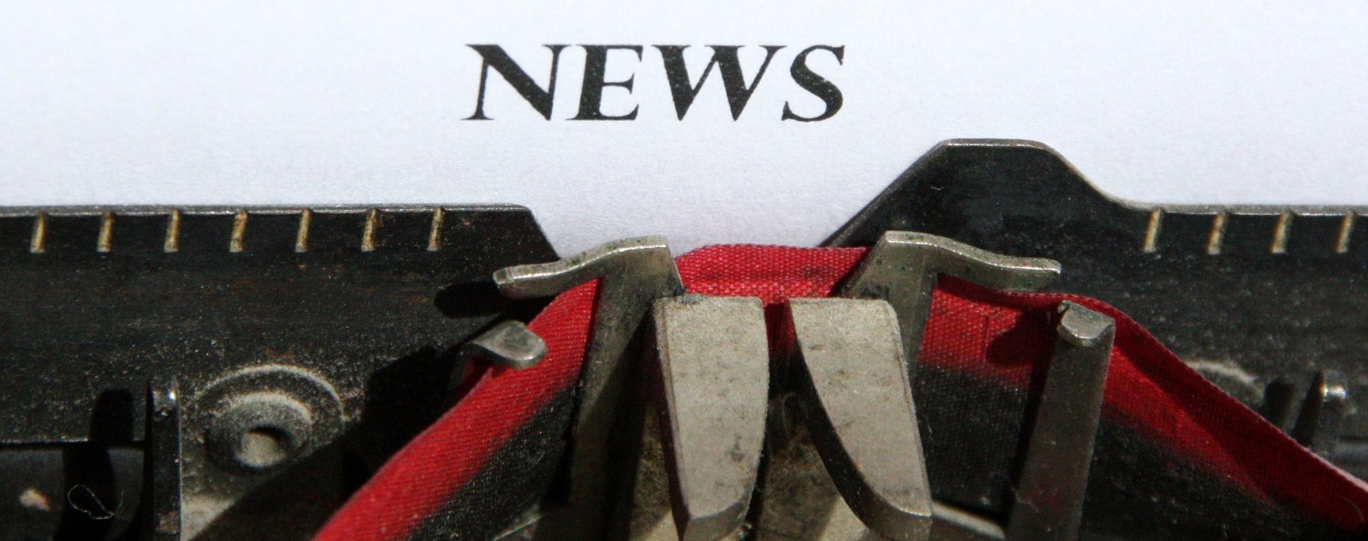 Das Wort News auf einem Blatt Papier abgebildet