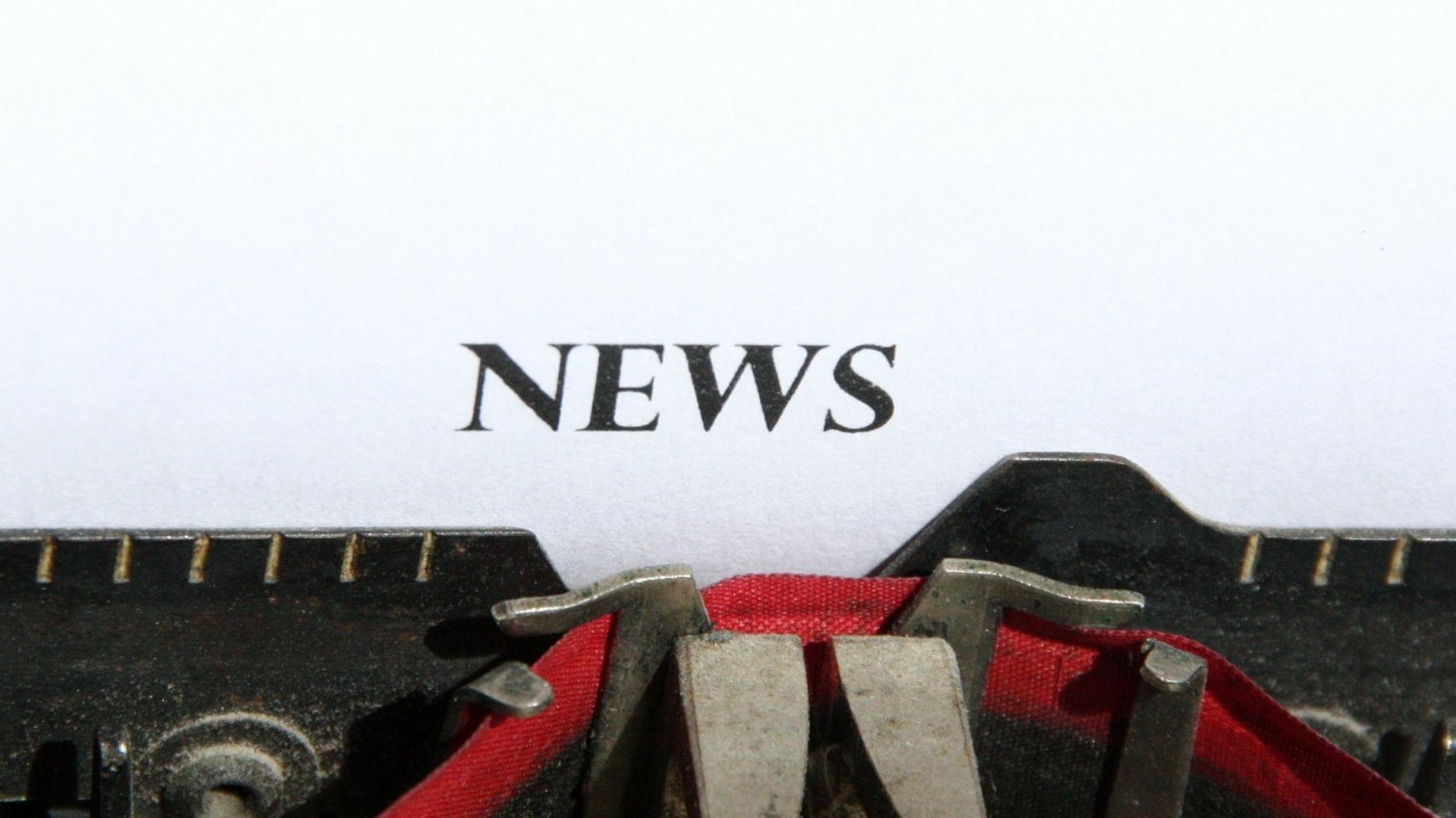 Das Wort News auf einem Blatt Papier abgebildet